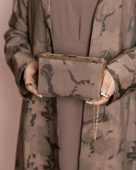 شنطة يد نسائية فاخرة بنفس نقشة عباية الجاكار مع طرحة متناسقة.